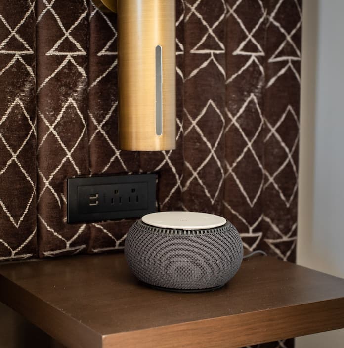 Snooz whitenoise machine on a bedside table in an Orli guest room