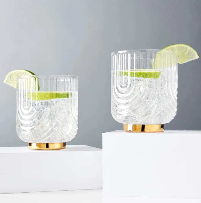 A set of Viski cocktail classes with a drink poured with two pieces of lime in each