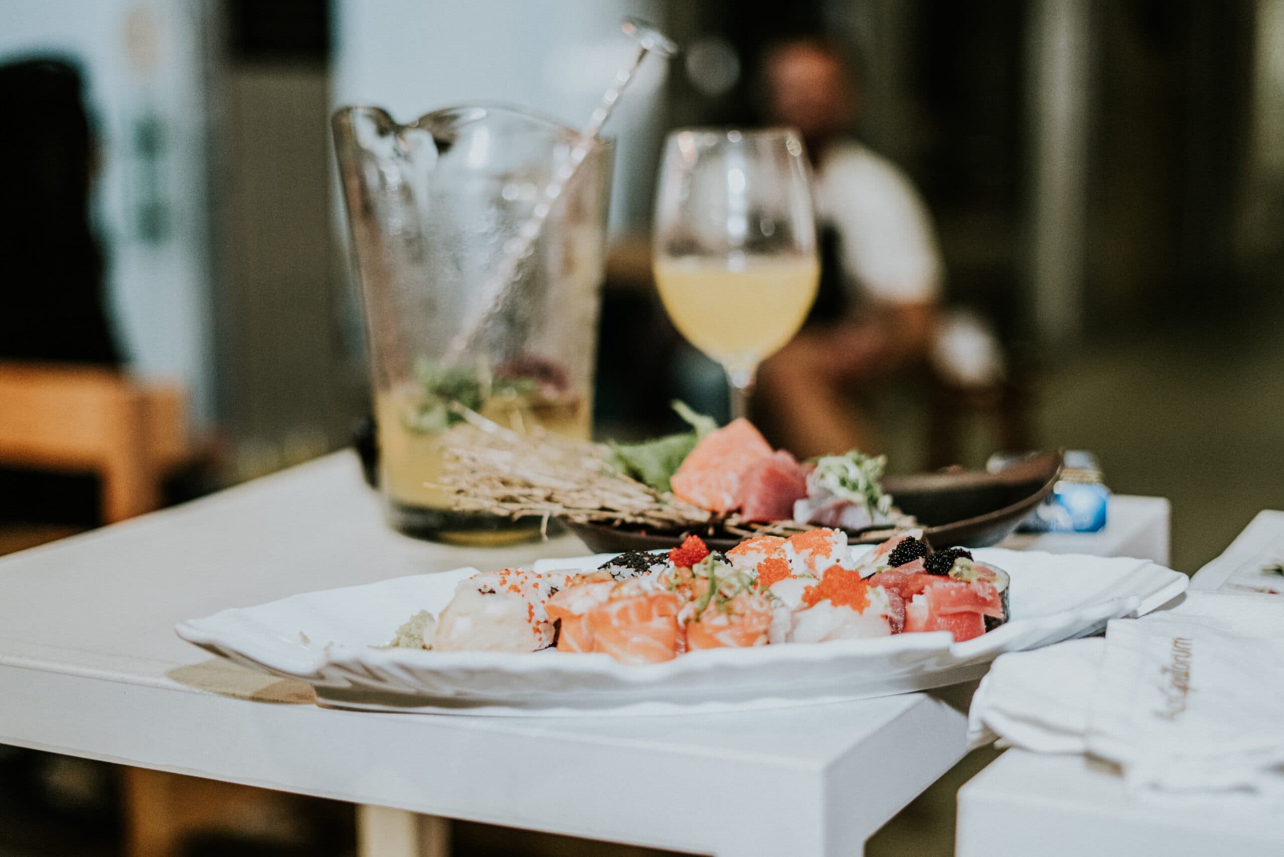 Partially eaten seafood dish on a restaurant table with a cocktail and wine glass in a refined dining setting