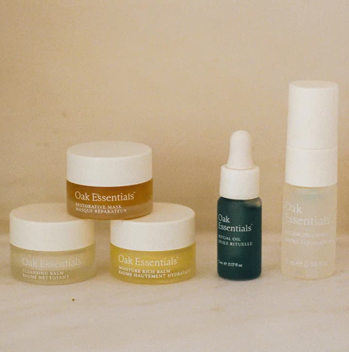 Oak Essentials skincare products including moisturizers, facial oil, and hydrating mist arranged on a neutral background