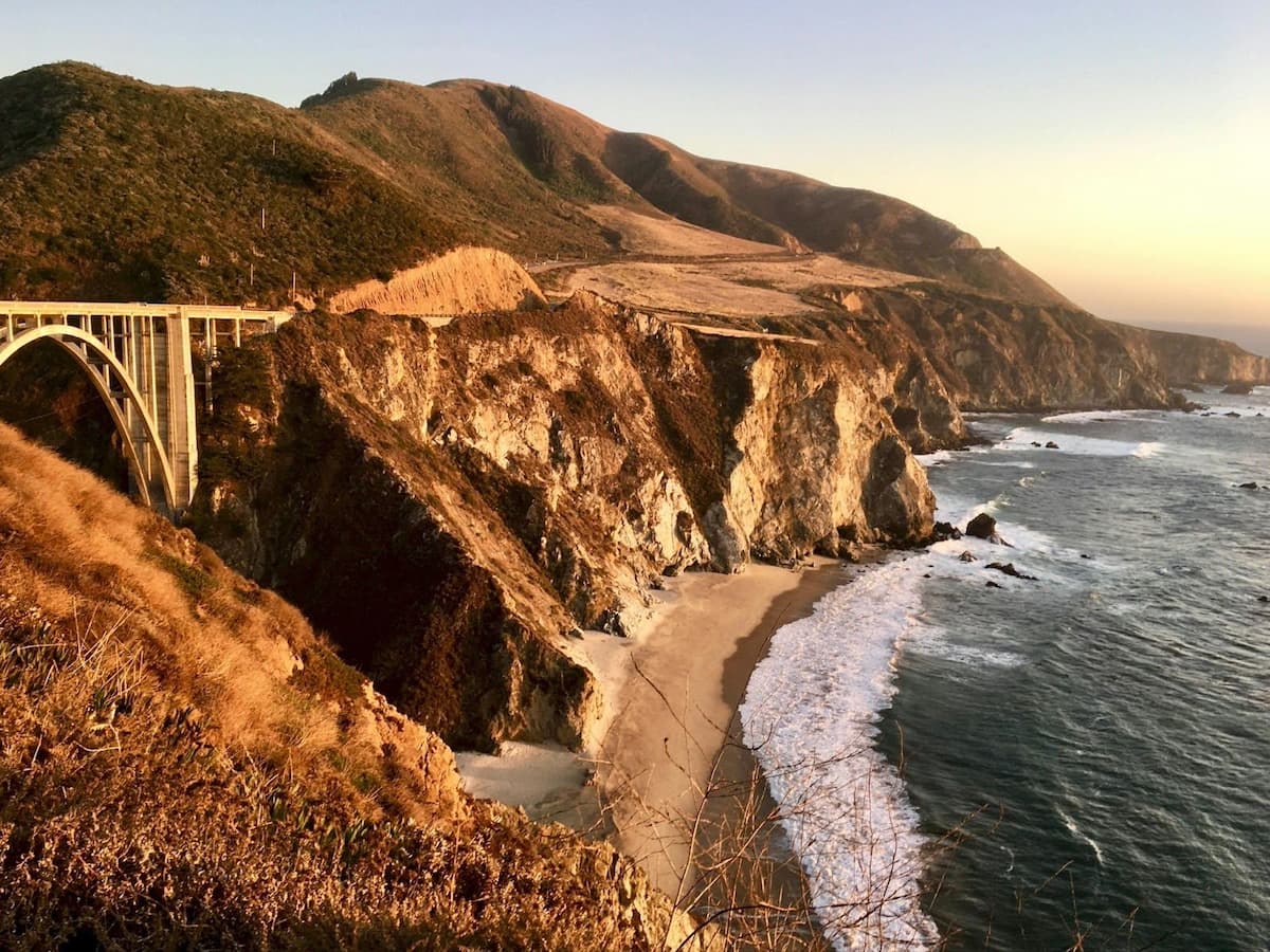 cliffside road with a bridge and the ocean