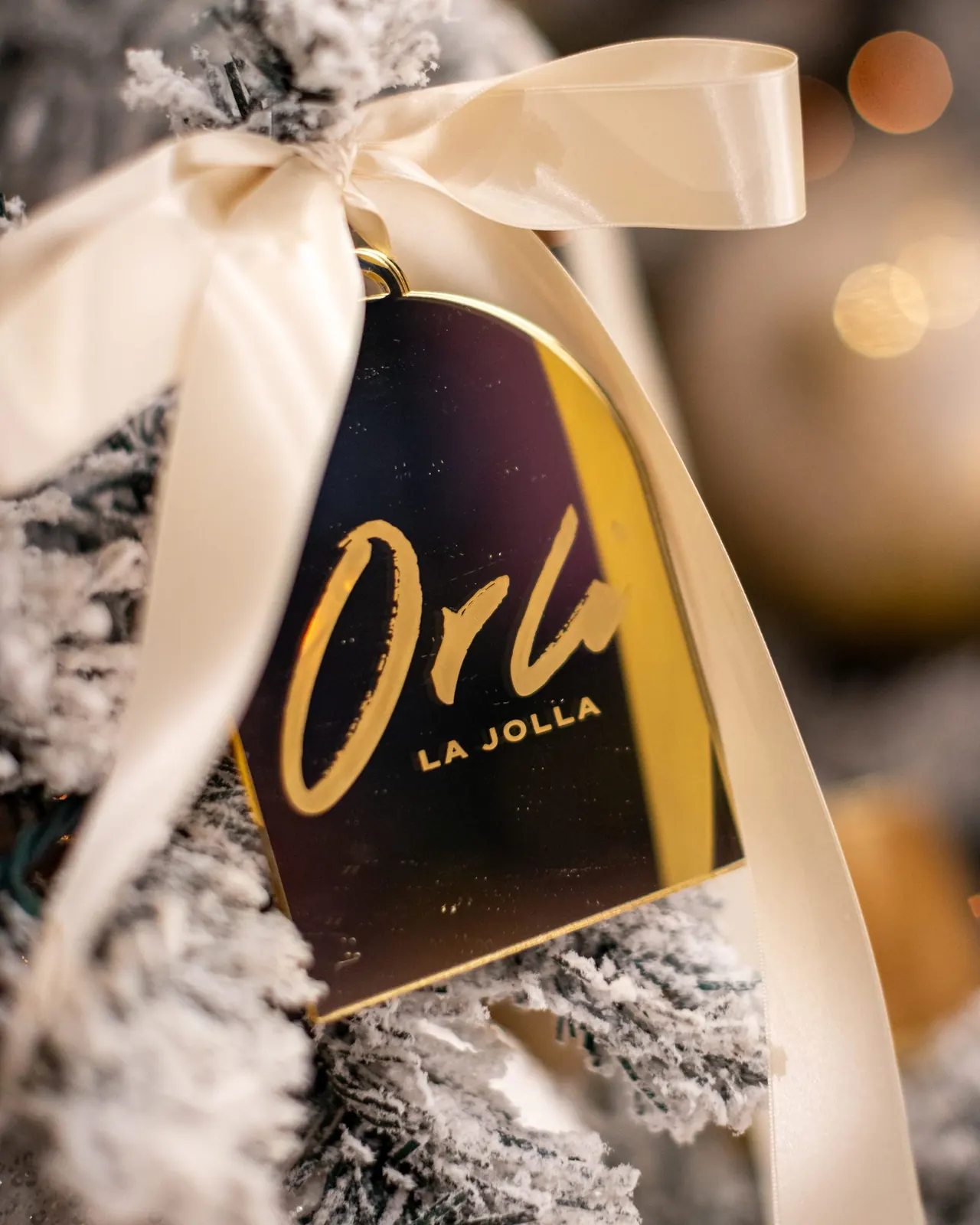 Orli La Jolla holiday ornament on a flocked Christmas tree