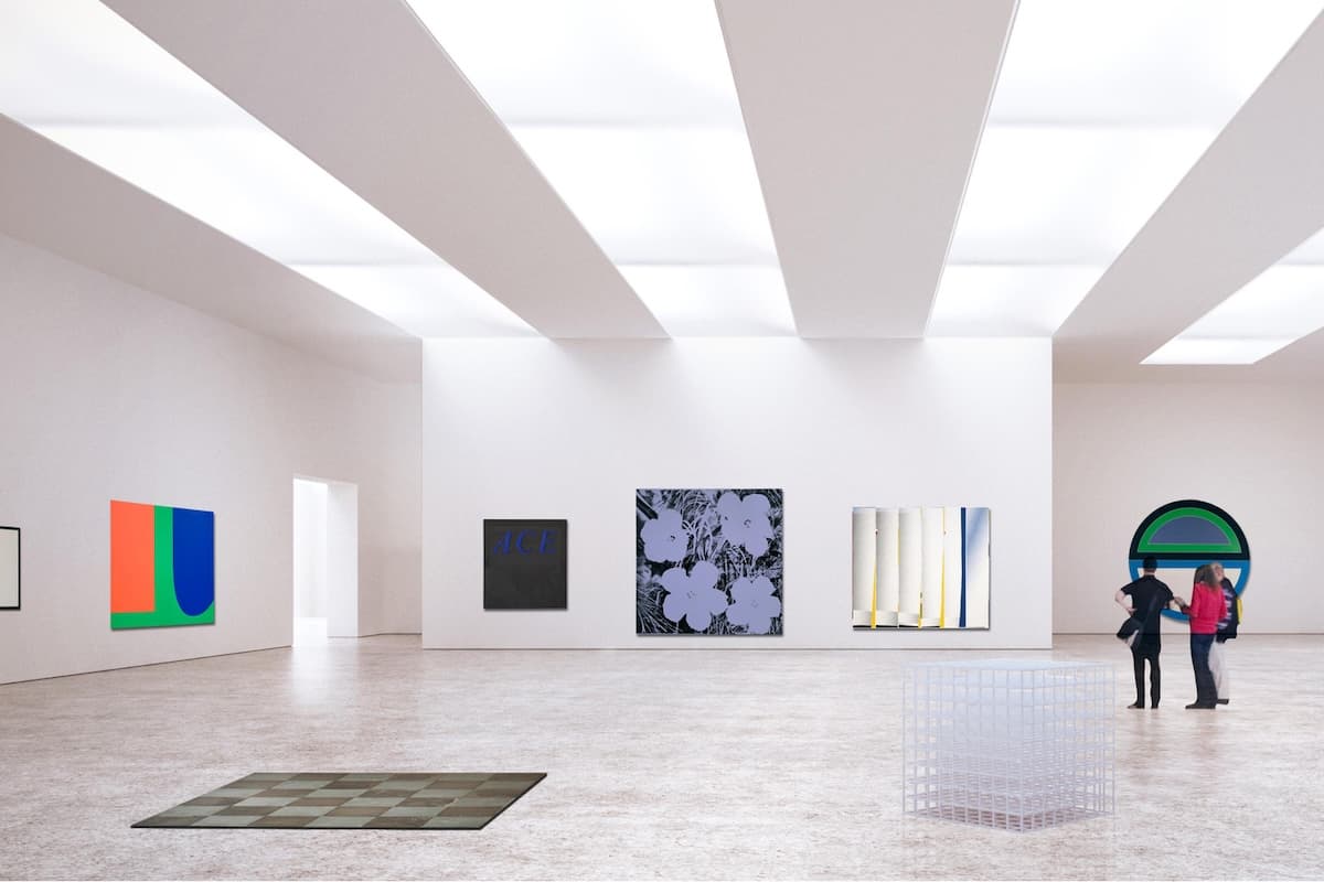Wide, minimalist gallery interior with white walls and skylit ceiling panels, displaying several large contemporary artworks in bold colors and abstract forms; two visitors stand near a circular wall piece on the right, while geometric sculptures sit on the polished floor.